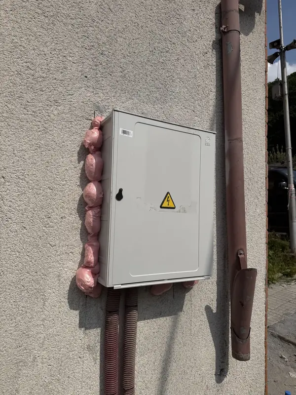 Přípojková skříň s chráničkami kabelů na fasádě domu